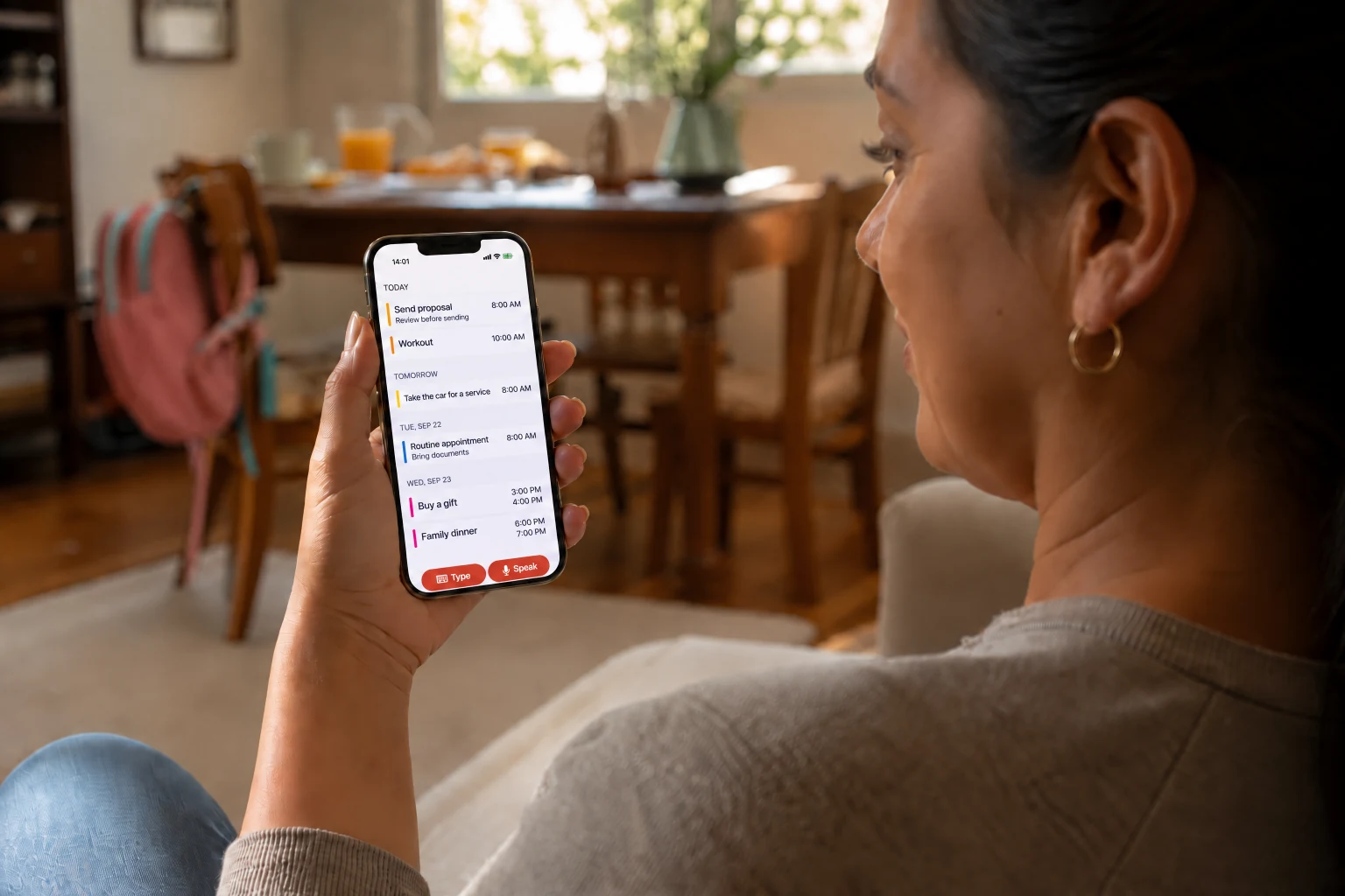 A woman checking the schedule organized by Plana on iPhone at home